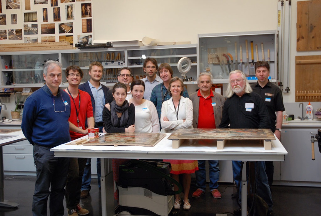 Ett team av konstkonservatorer samlade i ett museumslaboratorium, där de arbetar med historiska konstverk.