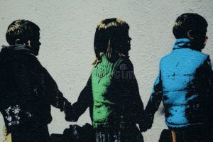 Graffiti som visar tre barn i profil som håller varandra i händerna, med färgade kläder.