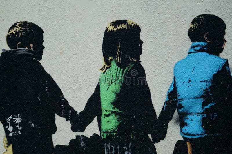 Graffiti som visar tre barn i profil som håller varandra i händerna, med färgade kläder.