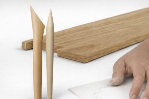 Träverktyg, träbitar och en hand som arbetar med ett material, belyser hantverk.